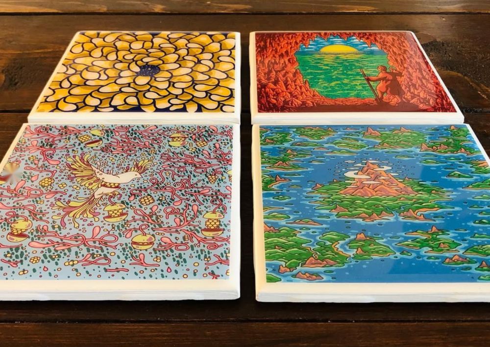 Four colorful label coasters with glossy resin tops on a wood table